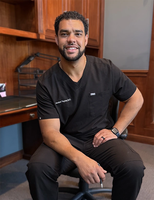 Chiropractor Flower Mound TX Andre Taylor HP Andre Taylor smiling while sitting in a chair.